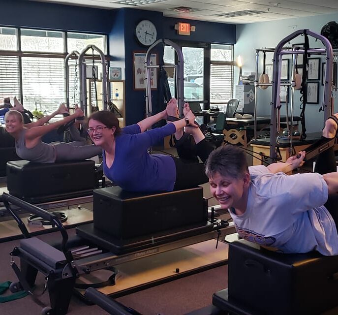 Group Pilates class using equipment in studio - Pilates equipment classes